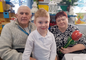 Oliwier pozuje do wspólnego zdjęcia razem z Babcią i Dziadkiem.