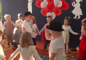 Dzieci ustawione w kole. Dwaj chłopcy ubrani w stroje bałwanków.