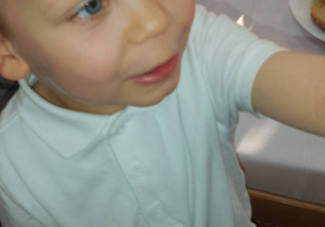 Uśmiechnięty Wojtek trzyma w ręku swoje laurki.