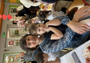 Laurka pozuje do zdjęcia siedząc na kolanach u swojej babci.