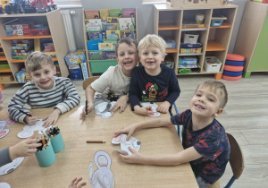 Olek, Franek, Karol i Ignacy kolorują wycięte z papieru maski z wizerunkami myszy.