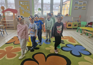 10. Dzieci poruszają się na dywanie między rozłożonymi pachołkami udając chód pingwinów.