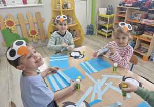 7. Ignacy, Staś i Alicja siedzą przy stoliku w trakcie tworzenia pracy plastycznej.