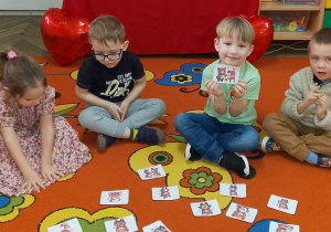Józio trzyma obrazek z misiem. Obok siedzi dwóch kolegów i koleżanka.