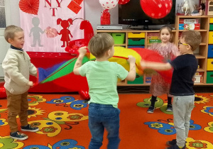 Dzieci podrzucają balon na chuście animacyjnej.