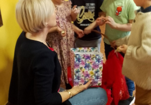 Pani dyrektor częstuje dzieci cukierkami.