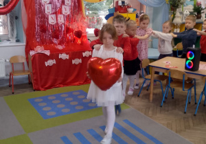 Emma trzyma czerwone balonowe serce i prowadzi "węża".