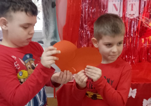 Mikołaj i Kuba trzymają połówki czerwonego serca.