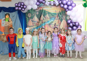 Dziewczynki z biedronek pozują do zdjęcia. W tle dekoracja indiańska.