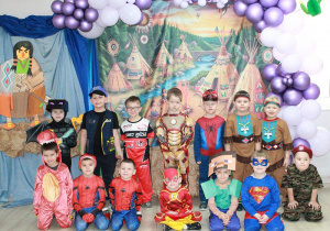 Dzieci z Biedronek pozują do zdjęcia grupowego. W tle dekoracja indiańska.