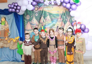 Dzieci ze Słoneczek przebrane w stroje indiańskie pozują do zdjęcia.