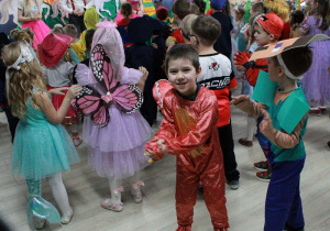 Wojtuś przebrany w strój smoka tańczy w rytm muzyki.