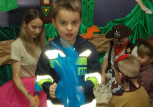 Leon przebrany w strój strażaka pozuje do zdjęcia.