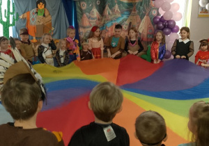 Dzieci uczestniczą w zabawach z chustą animacyjną.