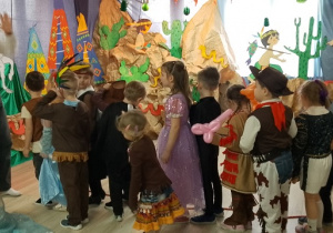 Dzieci biorą udział w konkursie. Są ustawione jedno za drugim.