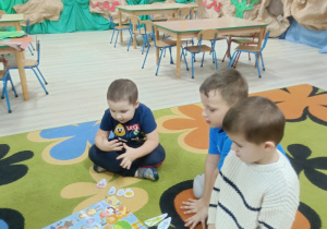 Przedszkolaki oglądają plakat ze strojami karnawałowymi. Wybierają stroje, za jakie sami by się przebrali.