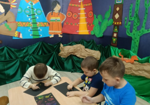 Dzieci wykonują wydzierankę karnawałową.