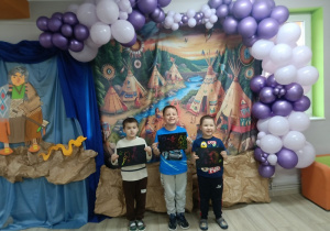 Chłopcy z Biedronek pozują do zdjęcia, trzymając w rękach wykonane wydzieranki.