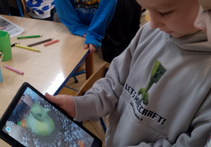 Chłopcy obserwują na tablecie „ożywionego”ptaszka.