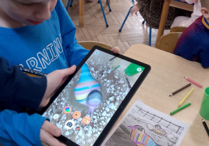 Fabian na tablecie obserwuje „ożywionego”ptaszka.