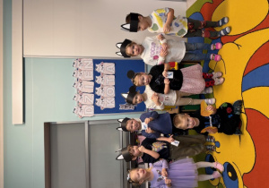 Grupa pszczółek pozuje do zdjęcia w kocich opaskach.