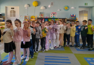 Dzieci stoją ustawieni w pociąg. Mateusz trzyma postać Dinka.