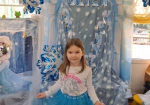 Weronika pozuje do zdjęcia na tle dekoracji.