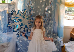 Amanda pozuje do zdjęcia na tle dekoracji trzymając balon w kształcie śnieżynki.