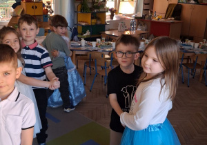 Dziewczynki z chłopcami tańczą w parach.