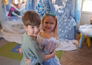 Tosia i Staś tańczą na tle dekoracji.