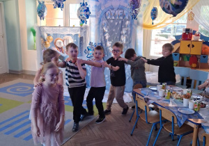 Dzieci ustawione w pociąg. W tle dekoracja z okazji "Dnia Dziewczynek".