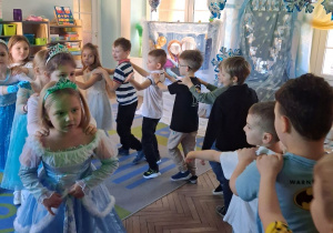 Dzieci ustawione w pociąg. W tle dekoracja z okazji "Dnia Dziewczynek".