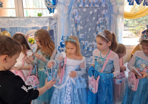 Marcel rozdaje dziewczynkom długopisy i ołówki z motywem "Krainy lodu".