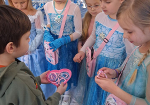 Mateusz rozdaje dziewczynkom bransoletki z motywem "Krainy lodu".