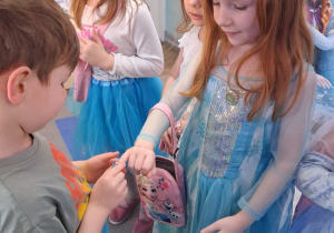 Staś zakłada Emmie na palec pierścionek.