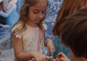 Staś zakłada Amandzie na palec pierścionek z motywem "Krainy lodu".