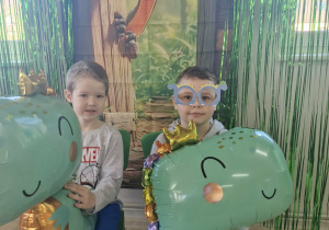 Julek i Oskar pozują do zdjęcia na tle dekoracji w sali.