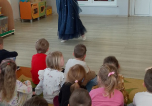 Dzieci oglądają "Taniec Księżyca" zaprezentowany przez tancerkę.
