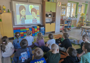 Dzieci oglądają film edukacyjny "Skąd się biorą produkty ekologiczne?".