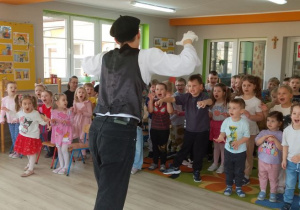 Dzieci podczas zabawy "Muzyczne kalambury" naśladują lwa.