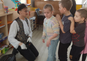 Pan przybija dzieciom pieczątkę na rączkach.