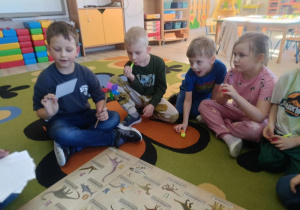 6. Dzieci dopasowują obrazki dinozarów do tych, które znajdują się na plakacie.