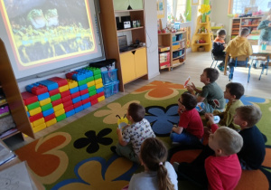 1. Dzieci z zainteresowaniem patrzą na tablicę multimedialną, na której jest wyświetlany film.