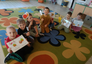 2. Dzieci oglądają ćwiczenia aparatu artykulacyjnego na ilustracjach i trzymają w rączkach obrazki zwierzątek, jakie można spotkać na łące.