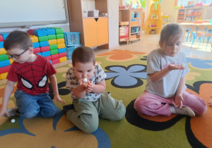 3. Antek, Szymek i Weronika dmuchają na piłeczki steropianowe.