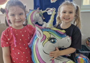 Ala i Klara pozują z balonem jednorożca.