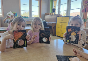 Zuzia, Nadia i Lilianka siedzą przy stoliku w trakcie tworzenia pracy plastycznej.