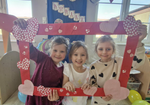 Maja, Zuzia i Liliana pozują do zdjęcia w foto-ramce.