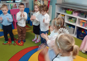 Dzieci klaszczą w ręce podczas zabawy przy muzyce.