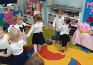 Dzieci w parach podczas zabaw przy muzyce, w tle dekoracja.